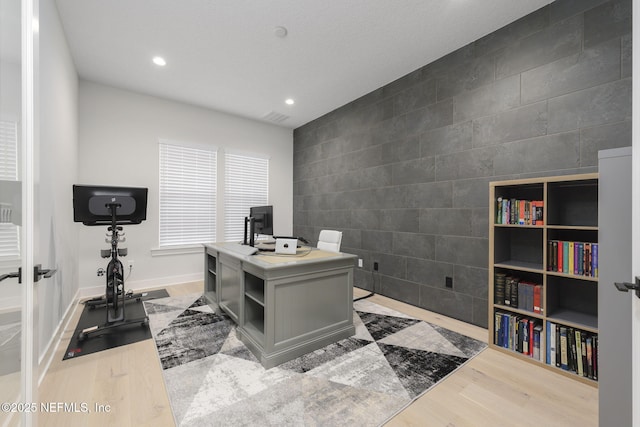 office with tile walls and light wood-type flooring