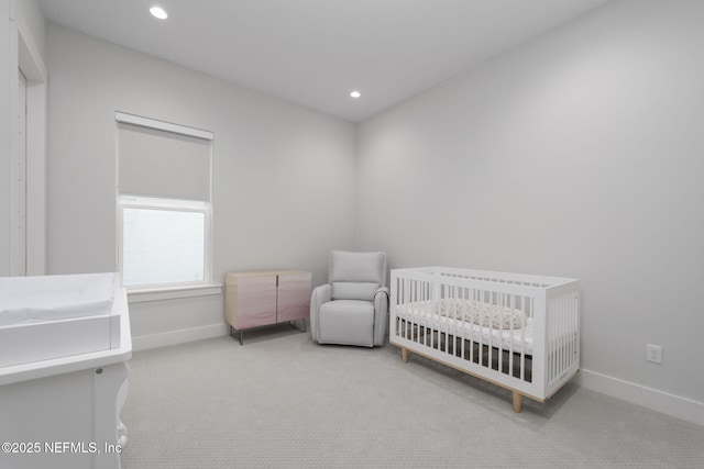 carpeted bedroom featuring a nursery area