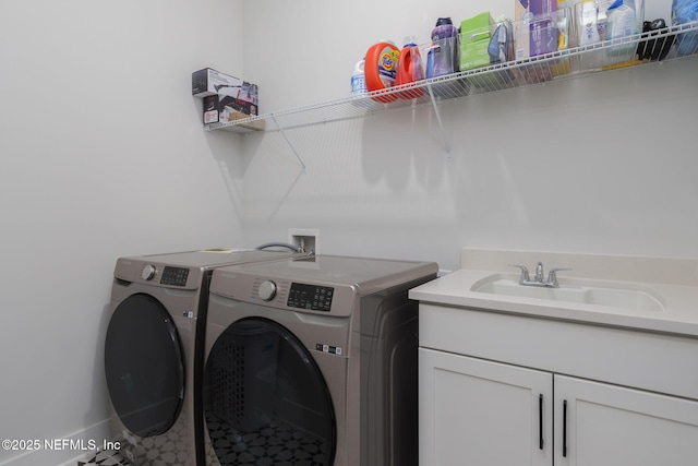 washroom featuring sink, washing machine and dryer, and cabinets