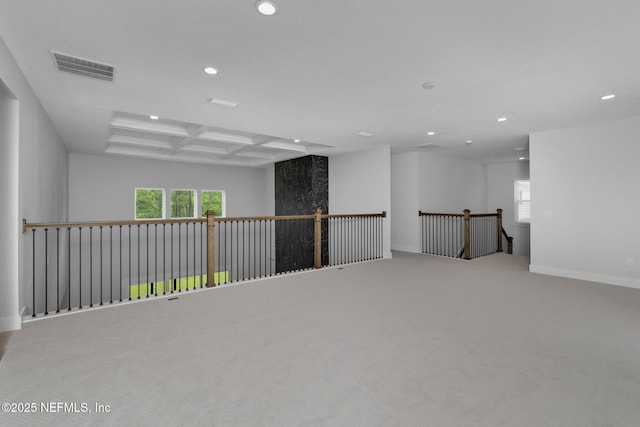 carpeted empty room with beamed ceiling, a healthy amount of sunlight, and coffered ceiling