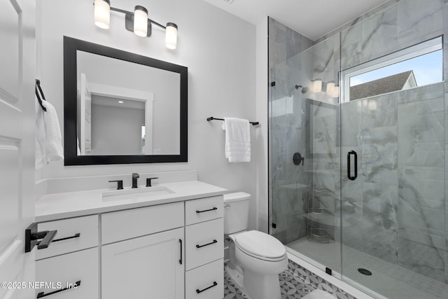 bathroom featuring vanity, toilet, and a shower with shower door