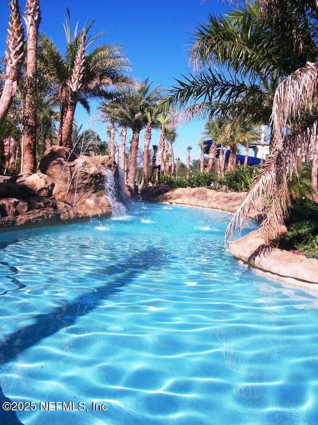 view of swimming pool featuring a water view