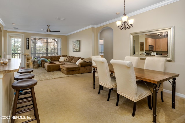 carpeted dining space with crown molding and ceiling fan with notable chandelier