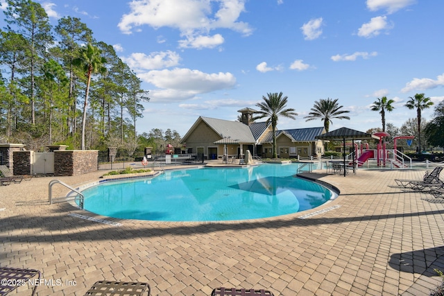 view of swimming pool featuring a playground and a patio area