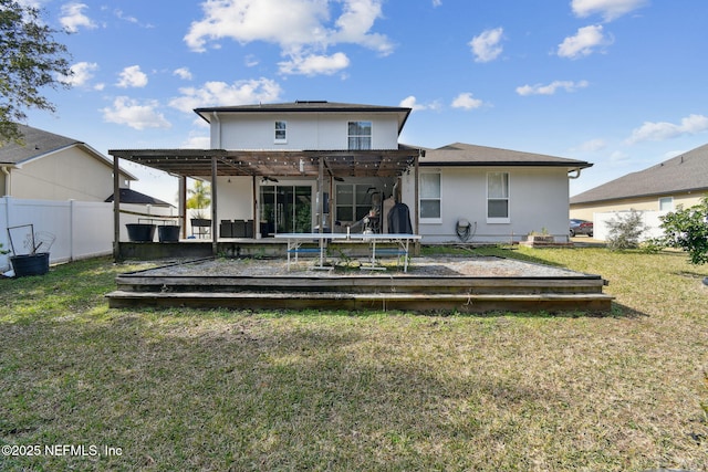 rear view of house featuring a yard, a trampoline, and a pergola