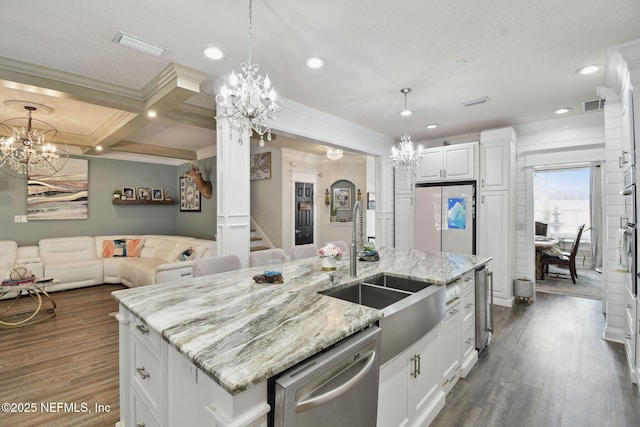 kitchen featuring white cabinetry, dishwasher, a notable chandelier, and an island with sink