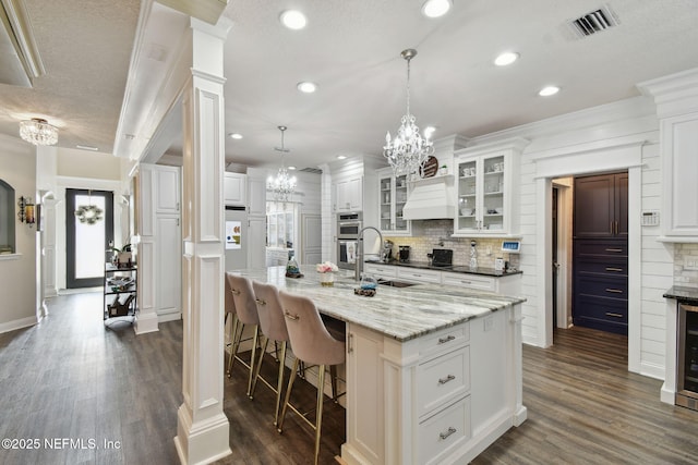 kitchen featuring white cabinetry, sink, pendant lighting, and a large island