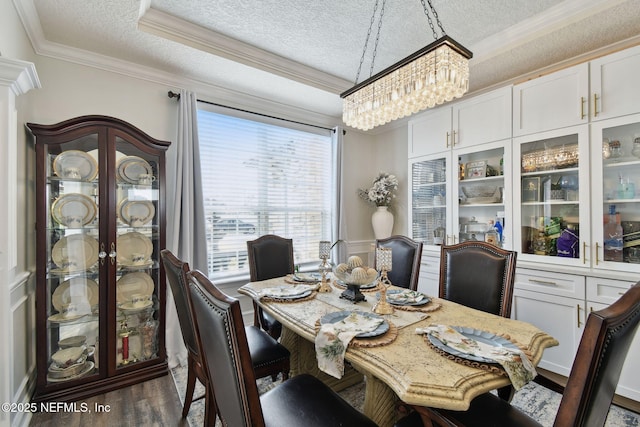 dining space featuring crown molding, dark hardwood / wood-style flooring, a chandelier, and a textured ceiling