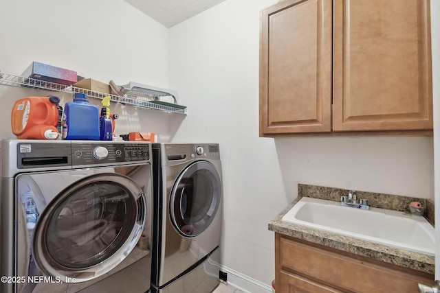 clothes washing area with cabinets, independent washer and dryer, and sink