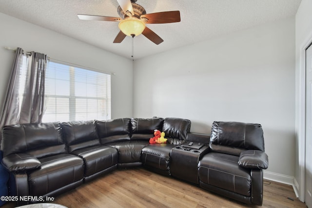 living room featuring ceiling fan, hardwood / wood-style floors, and a textured ceiling