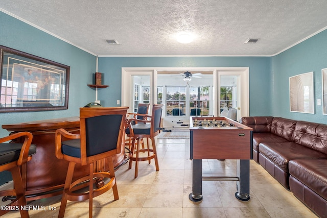 living room featuring ornamental molding, a textured ceiling, and light tile patterned floors