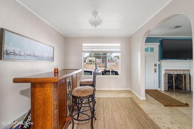 bar with ornamental molding and light tile patterned flooring