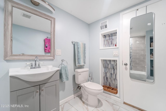 bathroom with vanity, toilet, and a tile shower