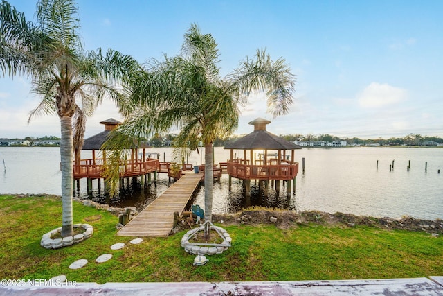 view of dock with a water view, a yard, and a gazebo