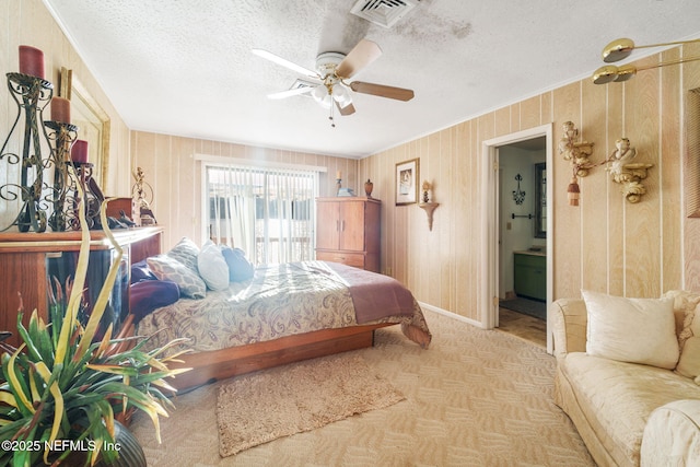 bedroom featuring a textured ceiling, ceiling fan, and ensuite bath