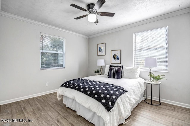 bedroom with hardwood / wood-style flooring, ornamental molding, ceiling fan, and a textured ceiling