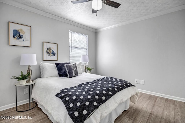 bedroom with crown molding, wood-type flooring, a textured ceiling, and ceiling fan