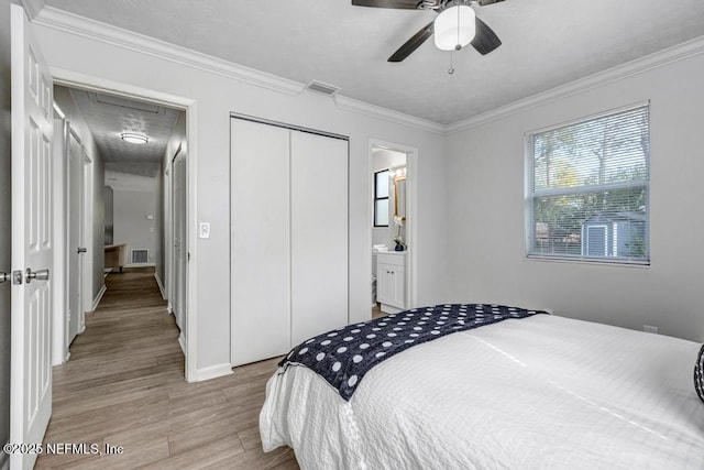 bedroom featuring ensuite bathroom, crown molding, light wood-type flooring, a closet, and ceiling fan