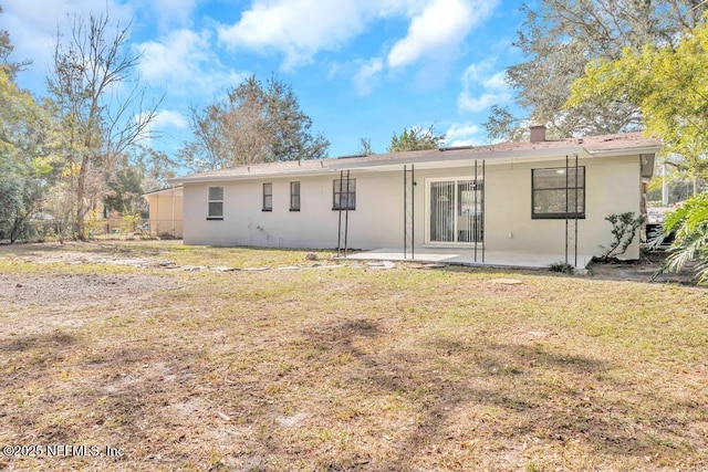 back of house with a patio area and a lawn