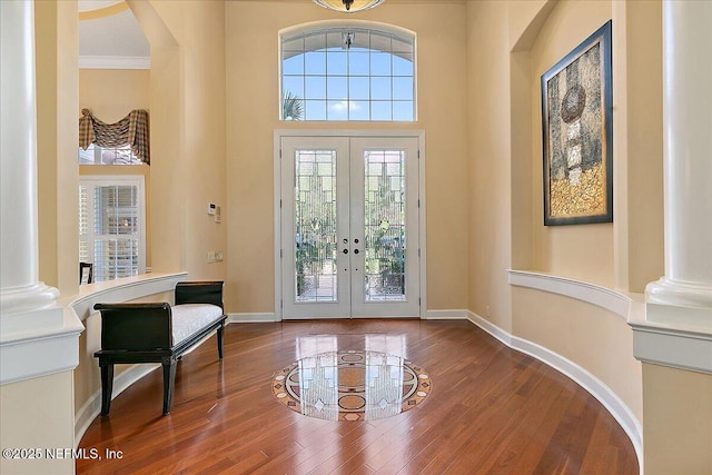 entryway featuring french doors, hardwood / wood-style floors, and decorative columns