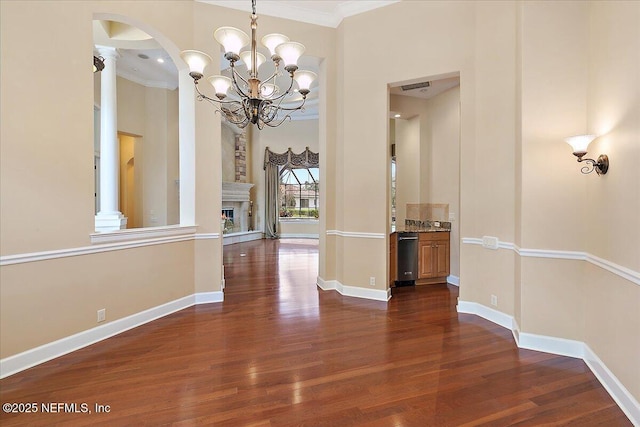 corridor with dark wood finished floors, visible vents, crown molding, and baseboards