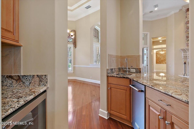 kitchen featuring a sink, dark wood finished floors, wine cooler, crown molding, and light stone countertops