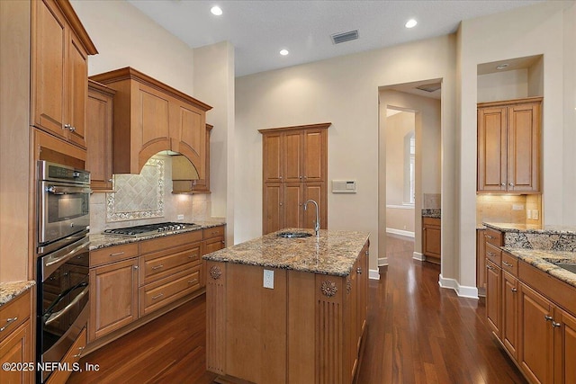 kitchen with visible vents, appliances with stainless steel finishes, dark wood-type flooring, and a sink