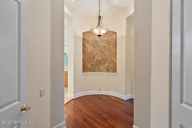 corridor with baseboards and dark wood-style flooring