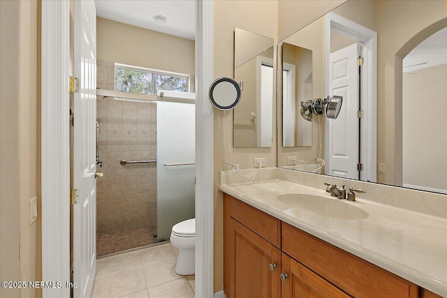 bathroom featuring vanity, a shower stall, toilet, and tile patterned flooring