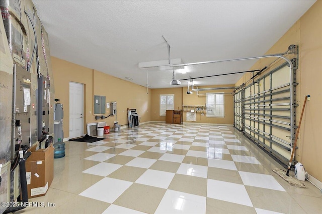 garage featuring electric panel, baseboards, and a garage door opener