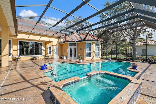 view of pool with a patio area, glass enclosure, french doors, and a pool with connected hot tub