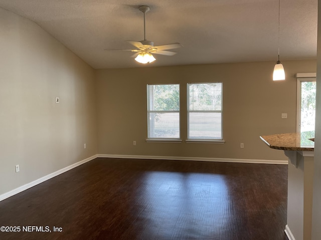 unfurnished living room with ceiling fan and dark hardwood / wood-style flooring