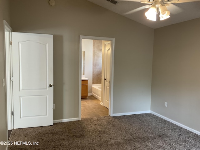 unfurnished bedroom with light colored carpet, ceiling fan, and ensuite bath