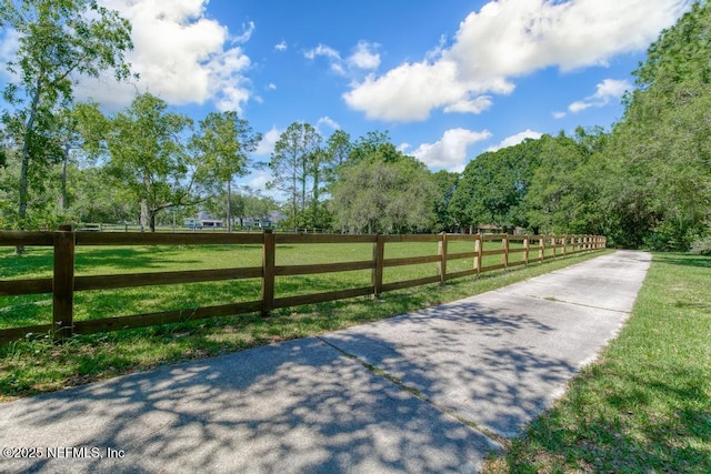 view of gate with a rural view and a yard