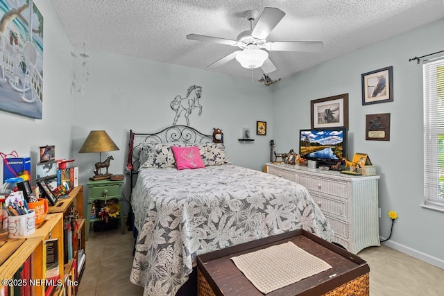 bedroom featuring ceiling fan, multiple windows, and a textured ceiling