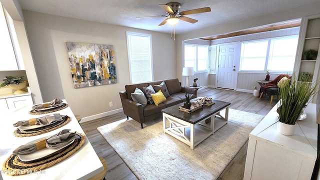 living room featuring hardwood / wood-style flooring, ceiling fan, and a textured ceiling