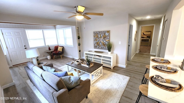 living room featuring light hardwood / wood-style flooring and ceiling fan