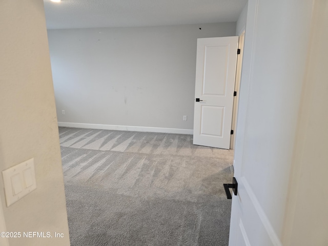 spare room featuring baseboards and carpet floors