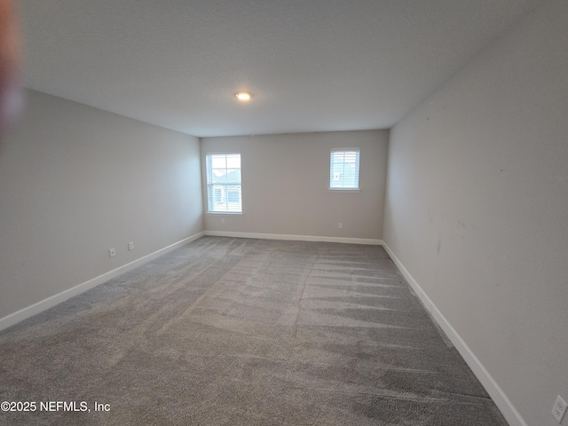 carpeted spare room featuring baseboards