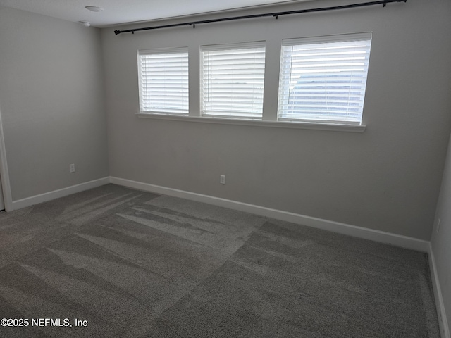 empty room featuring baseboards, a healthy amount of sunlight, and carpet flooring