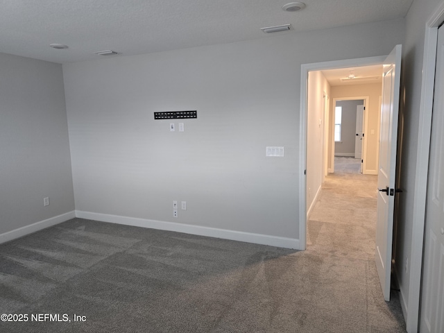 carpeted empty room featuring visible vents and baseboards