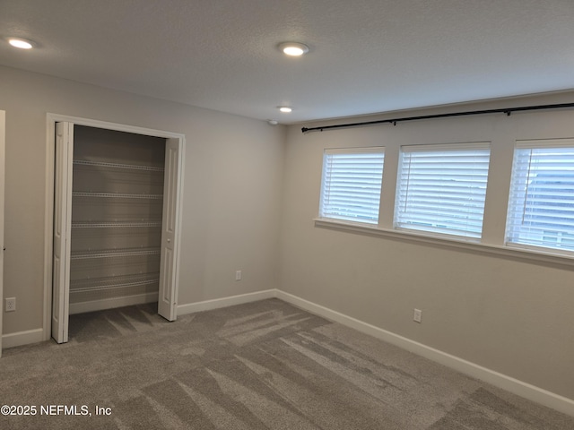 unfurnished bedroom with a textured ceiling, recessed lighting, a closet, carpet, and baseboards