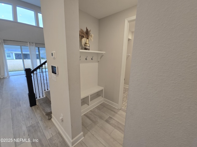 mudroom featuring baseboards, light wood-type flooring, and a wealth of natural light