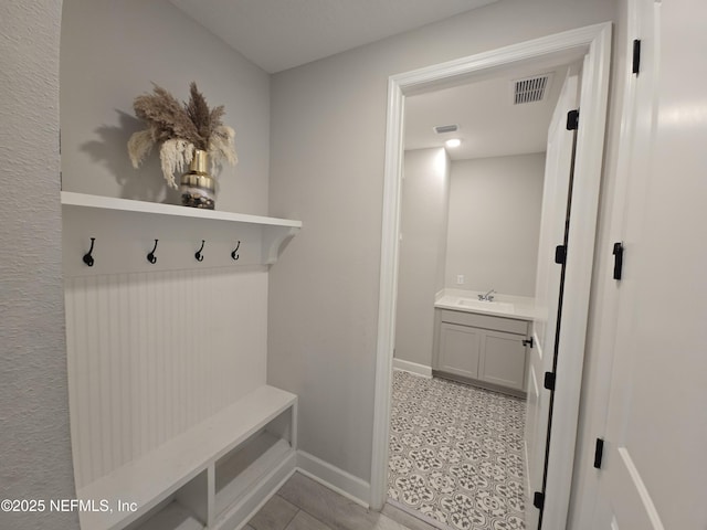 mudroom with sink and light tile patterned flooring