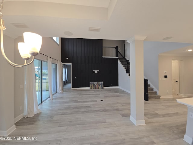 interior space with visible vents, crown molding, baseboards, light wood-type flooring, and stairs