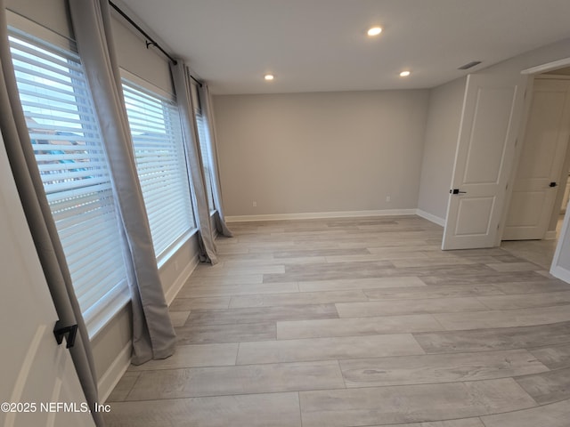 unfurnished room featuring recessed lighting, visible vents, light wood-style flooring, and baseboards