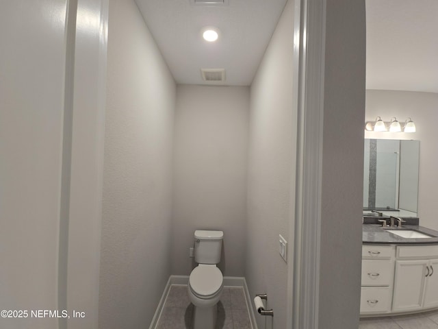 bathroom featuring vanity, tile patterned floors, and toilet