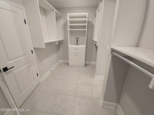 walk in closet with light tile patterned floors