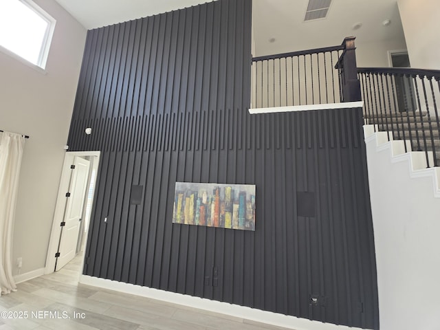 interior space with a towering ceiling and light wood-type flooring