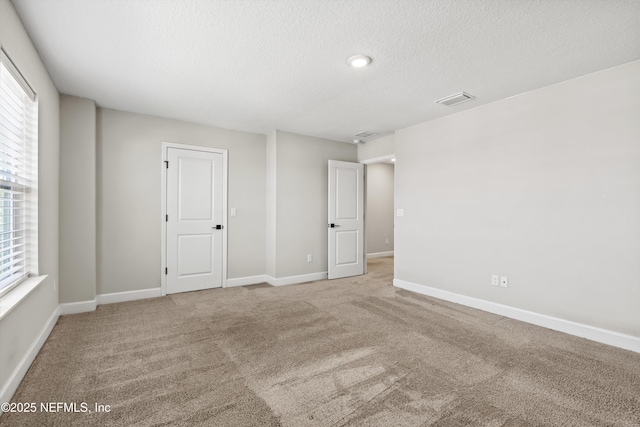 unfurnished room featuring carpet flooring and a textured ceiling